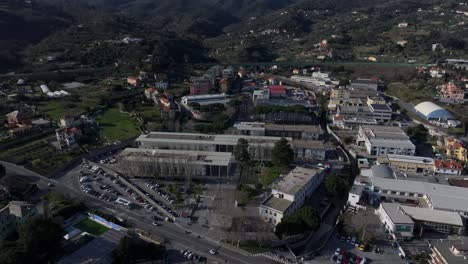 savona university campus surrounded by hills on a clear sunny day, aerial view