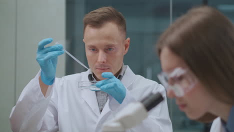 two chemists are testing samples of water during ecological and chemical expertise in laboratory of scientific institute male ad female experts