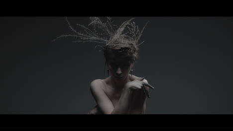 a woman dressed as mother nature moves slowly in a dance-like motion