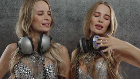 identical twin female dancers in sparkling silver costumes