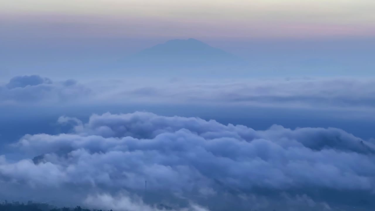 Hyperlapse above the clouds at sunrise. Morning sky, sunrise with yellow and blue sky. The clouds shrouded hills and mountain