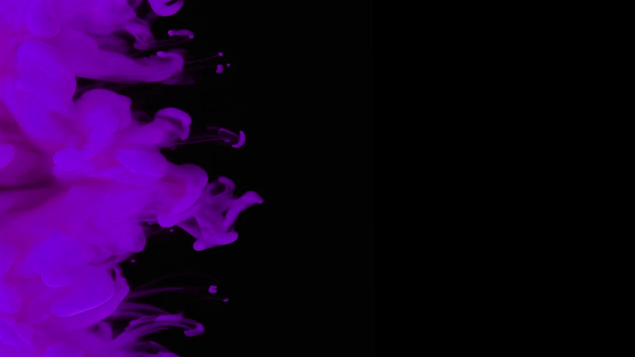 Inchiostro viola che si diffonde nell'acqua su sfondo nero