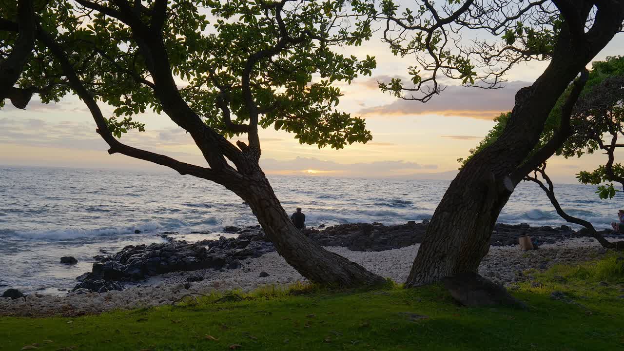 하와이 마우이의 바위투성이 해안선에서 석양을 바라보는 사람들