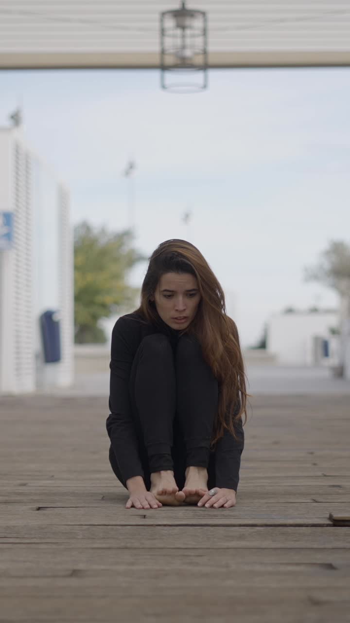 Uma Mulher Sentada Sozinha e Angustiada em um Píer