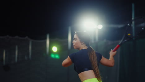 woman playing tennis at night