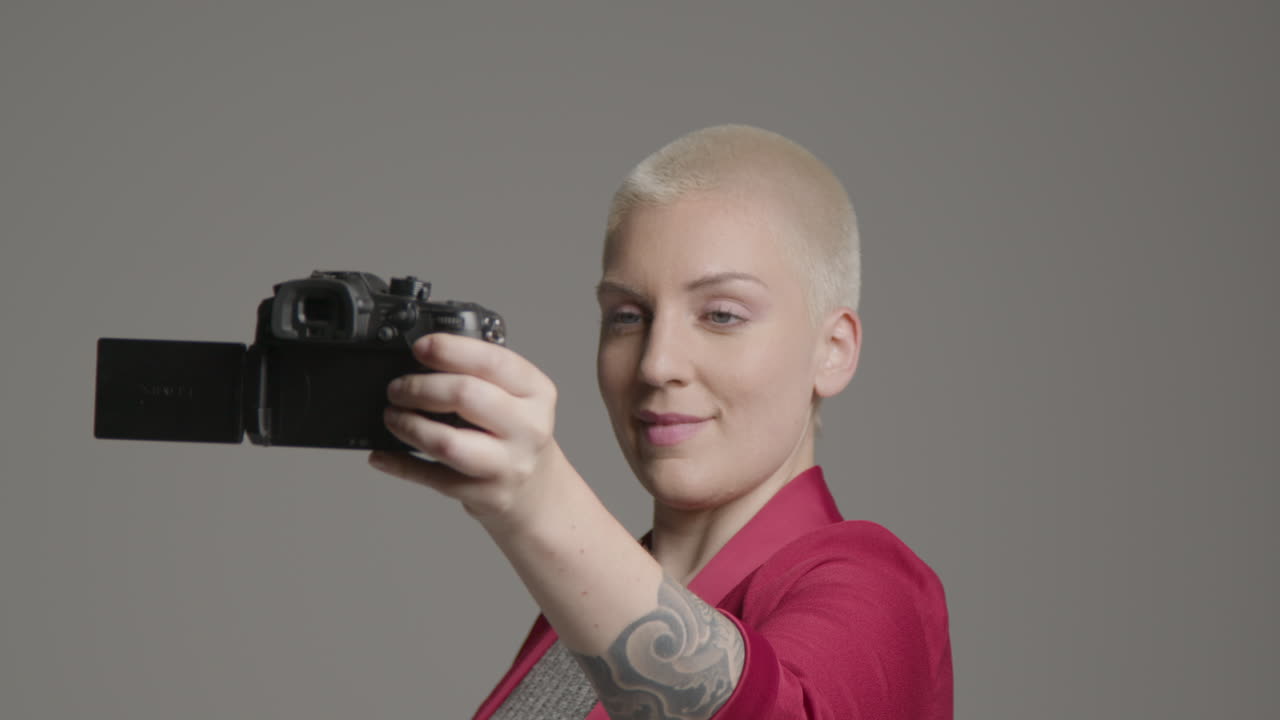 женщина-модель ведет влоггинг с зеркальной камерой