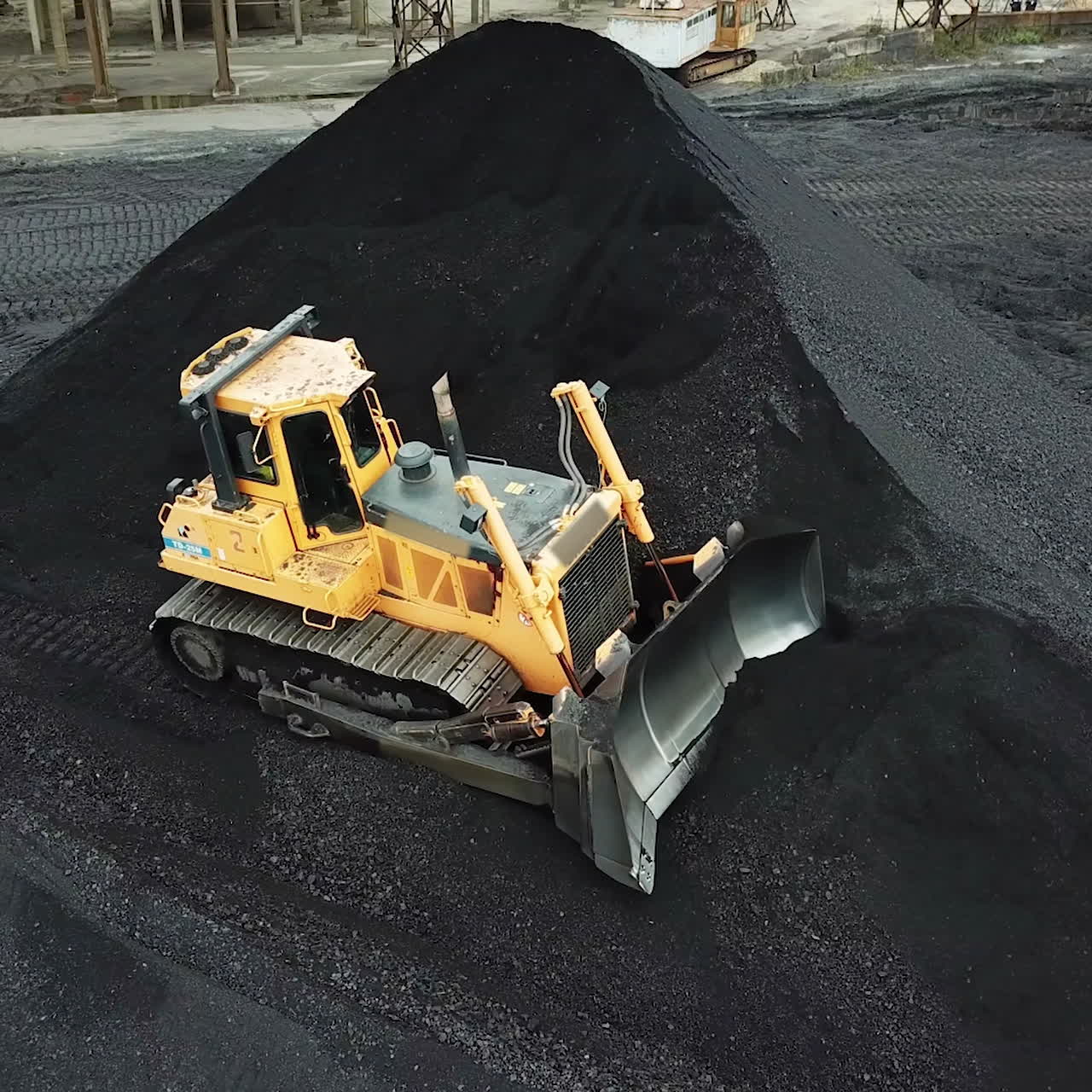 Gul bulldozer flytter kul. Udvindingsindustri. Luftfoto