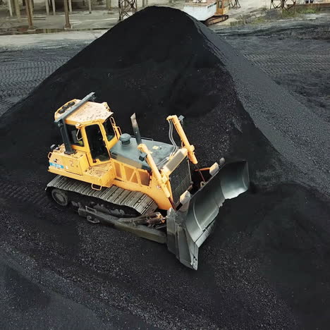 yellow bulldozer moves the coal. extractive industry. aerial view.