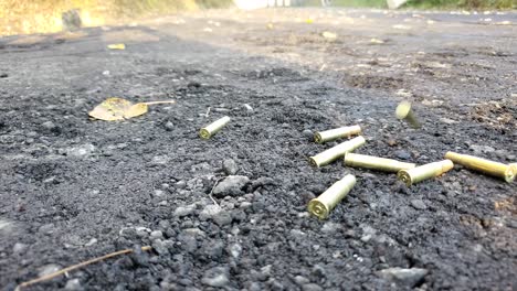 empty shell casings hitting the ground after being shot out of rifle