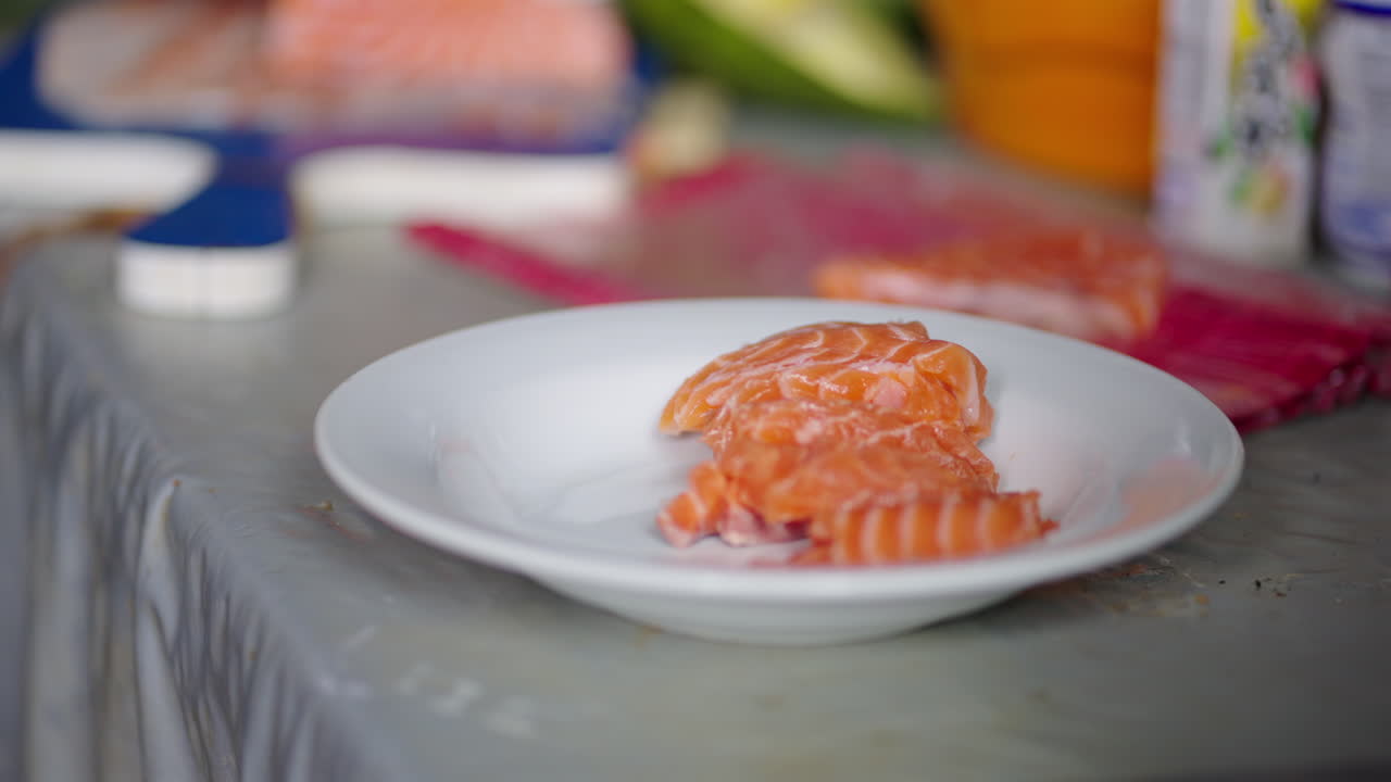 Fresh raw salmon slices on white plate prepared for sashimi or sushi