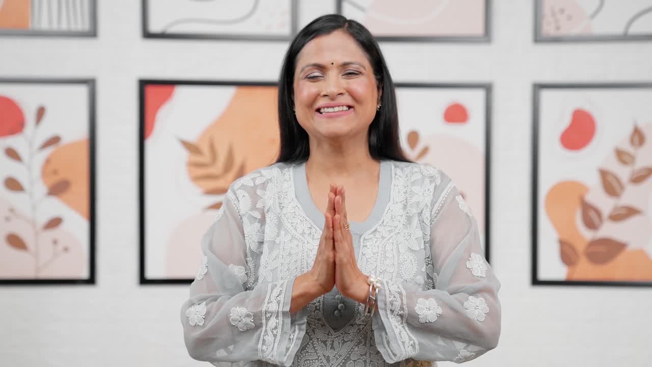 Indische Mutter, die Namaste sagt und grüßt