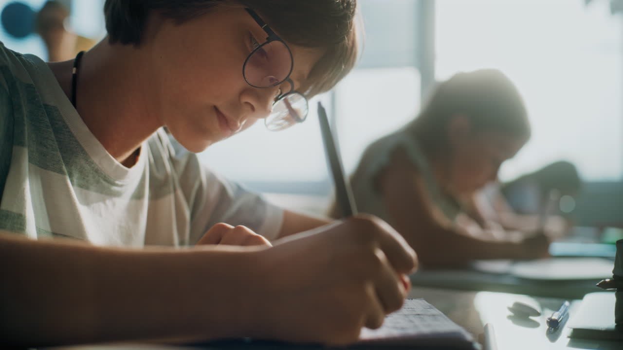 Elementary School Boy Writing Exam or Doing Task in Notebook