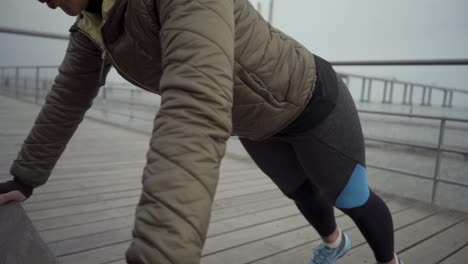 confident sportswoman exercising on wooden pier