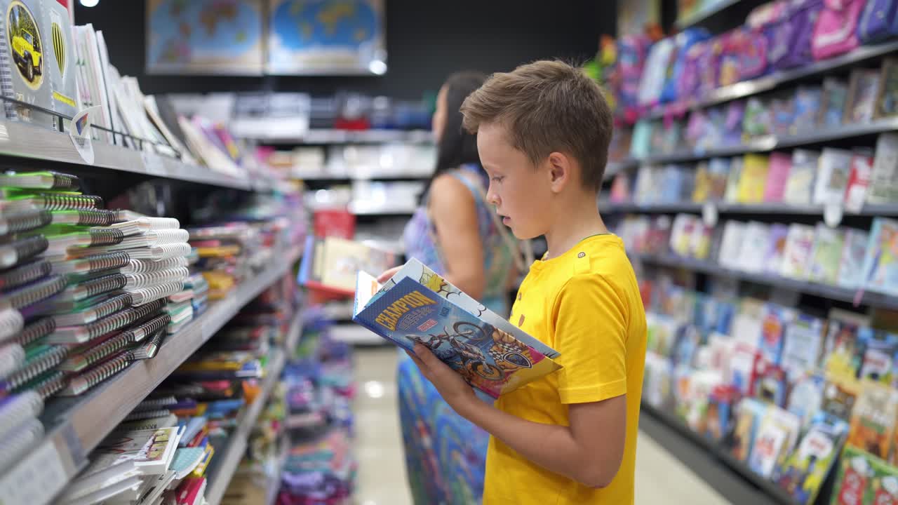 Boy choosing school stationery. Boy chooses stationery in the submarket