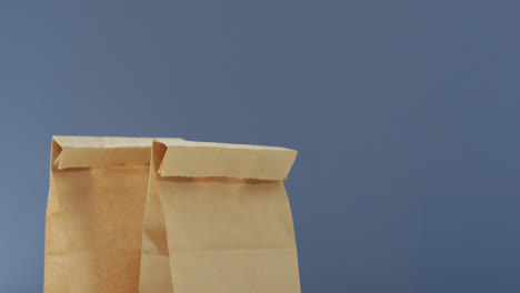 animation of paper lunch bags on blue background