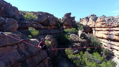 male highliner walkng on a rope over rocky mountains 4k