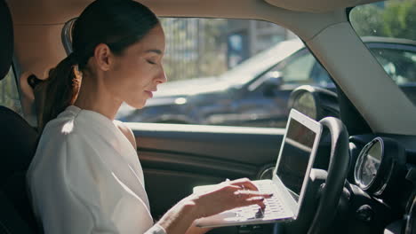 smart lady boss car looking laptop sitting at front seat closeup. woman working