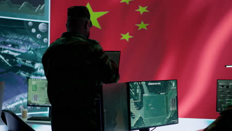 military analyst from china reviews surveillance data in an army monitoring room