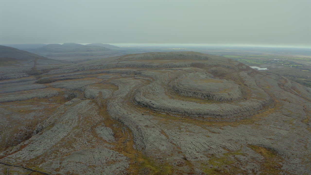 Dramatic slow-motion shot of Burren's iconic hill shrouded in misty skies. Ireland.