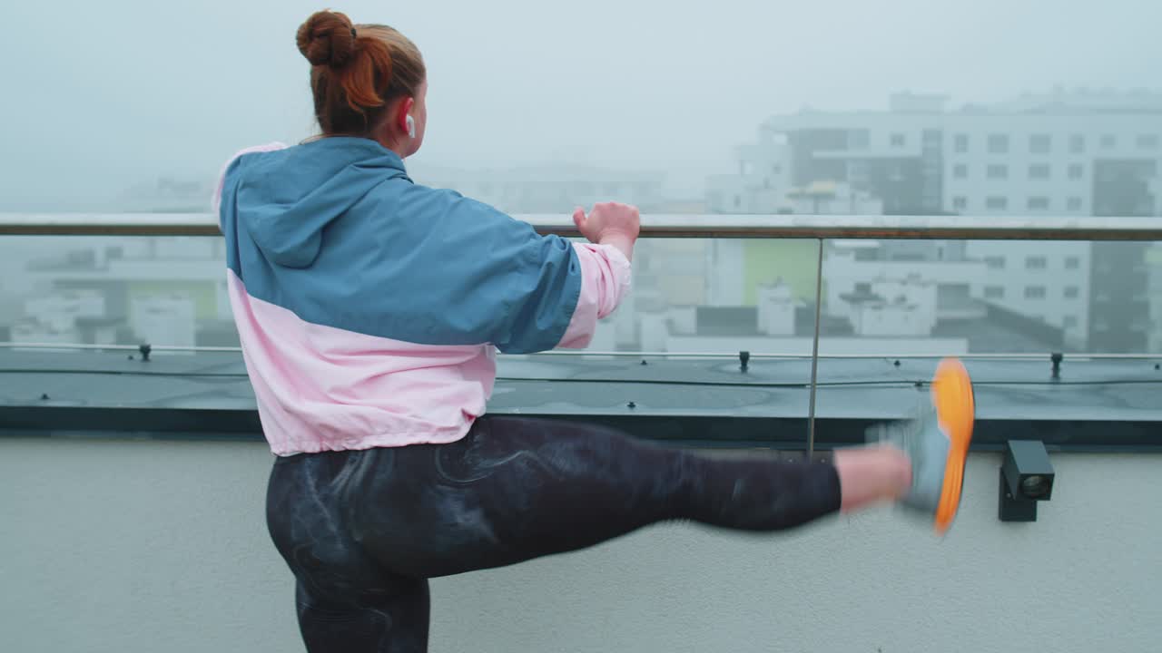 mujer en forma deportiva en ropa deportiva azul rosa haciendo sentadillas yoga estiramiento ejercicio en el techo de la casa