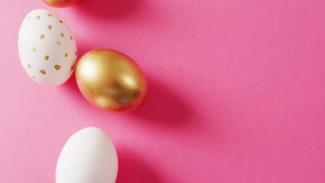 Close-up-of-white-and-gold-easter-eggs-on-pink-background-with-copy-space