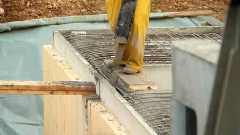 a construction worker fills fresh concrete into a shell wall of a basement