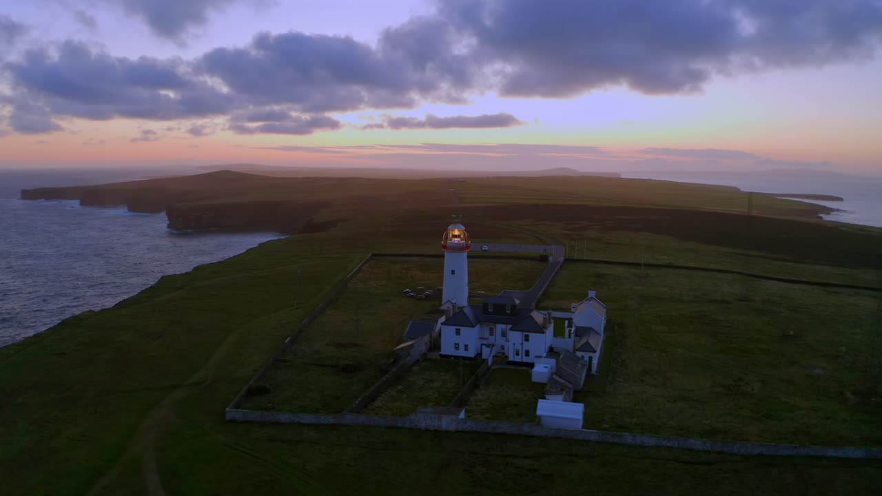 루프 헤드 등대 (loop head lighthouse) 의 놀라운 공중 도, 극적인 반도 위에서 활기찬 새벽 색으로 빛나고 있습니다.