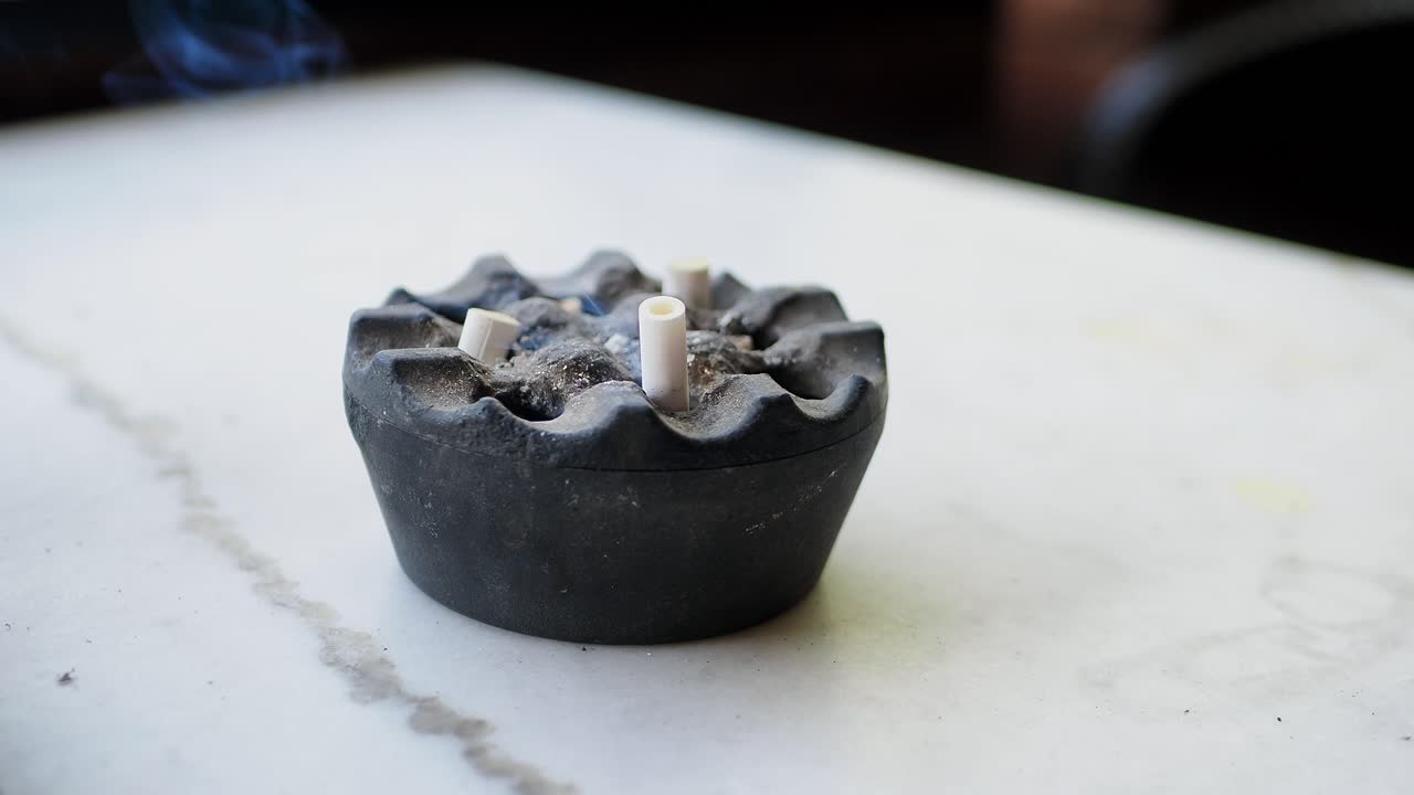 cenicero con cigarrillos y humo