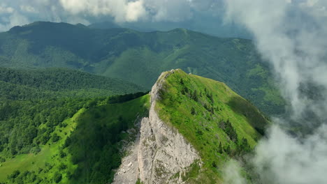 flying trough white fluffy clouds above green mountain peaks