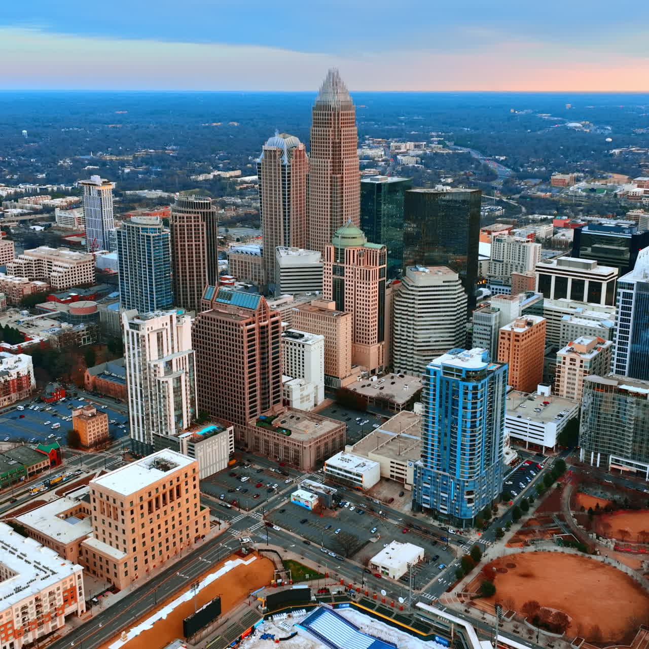 Flying closer to the high-rise architecture in the uptown of Charlotte, NC, US. Vast scenery with lots of greenery at backdrop.