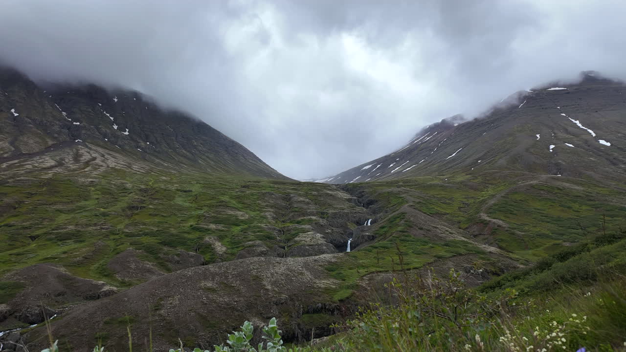 Captivating timelapse showing cloud formations flowing around the Útsýnispallur Grænafell in Iceland, displaying the ethereal interaction between mountains and weather systems