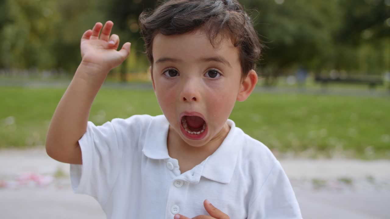 dulce niño gracioso de pie y posando en el parque de verano