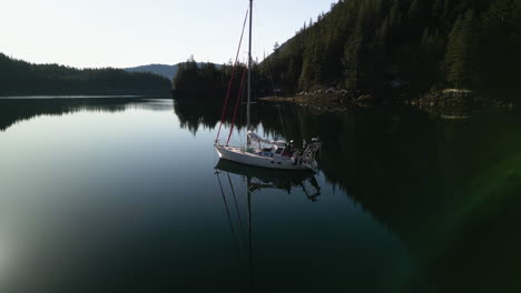 Drone-shot-of-a-saillboat-moored-in-still-waters-of-Prince-William-Sound,-Alaska