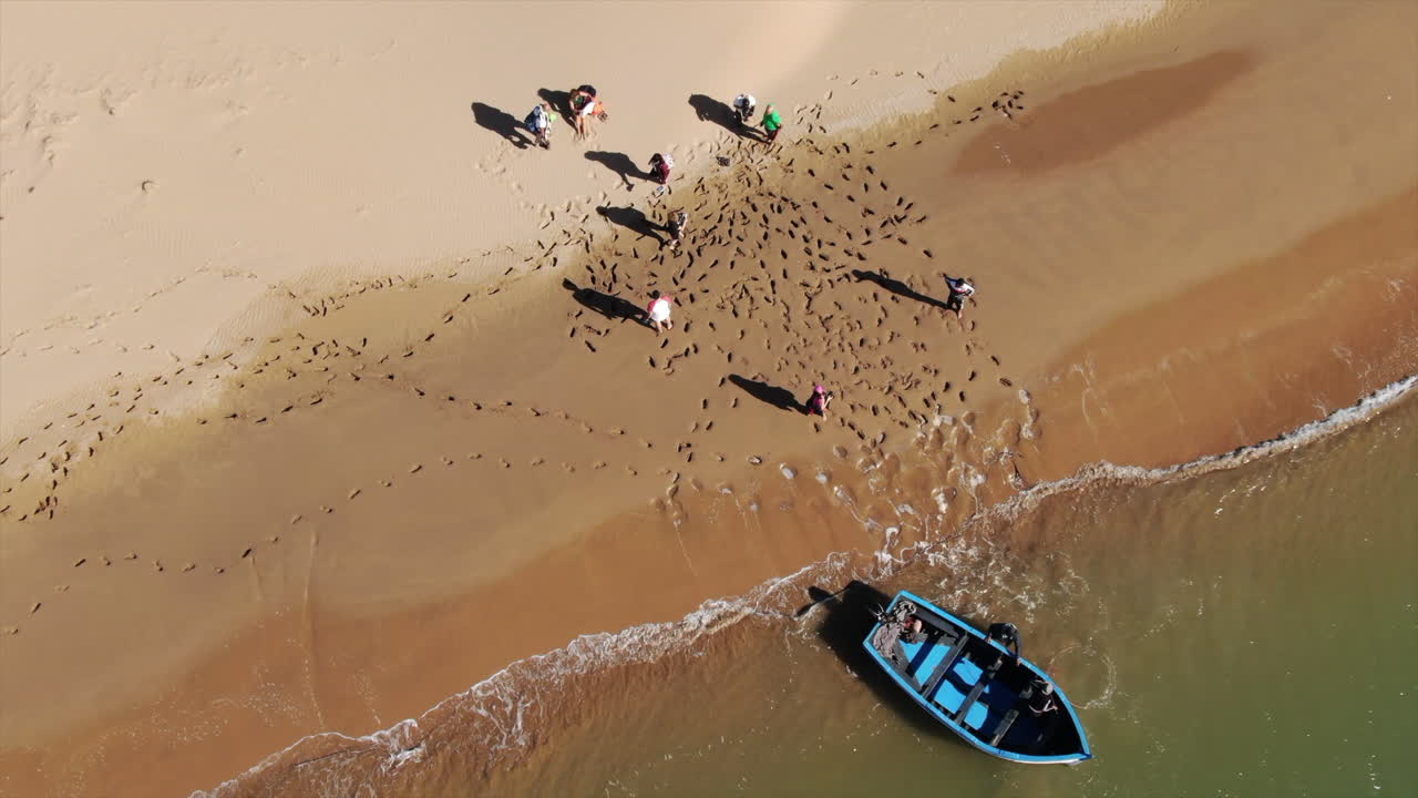 aerial shot of people walking along the shore of the Naila lagoon in Tarfaya, Morocco.