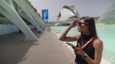 mujer usando el teléfono frente a la arquitectura moderna