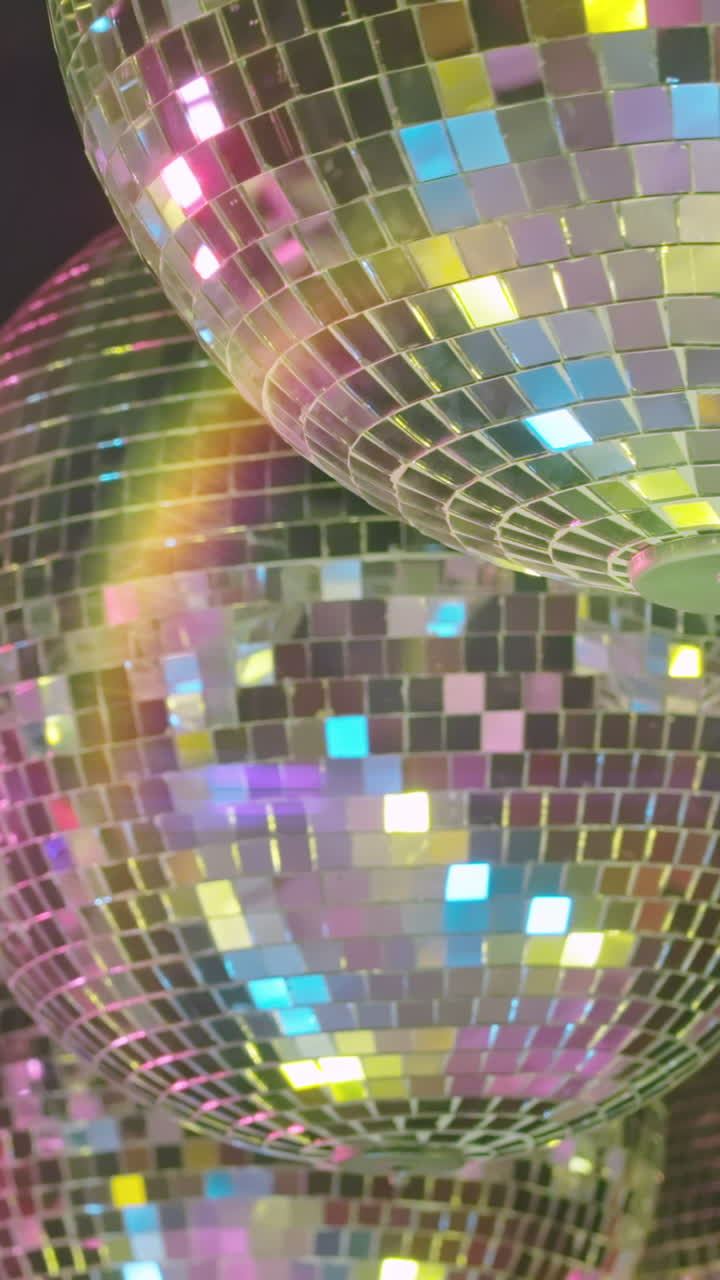 Sfere da discoteca vibranti che riflettono luci colorate da festa.