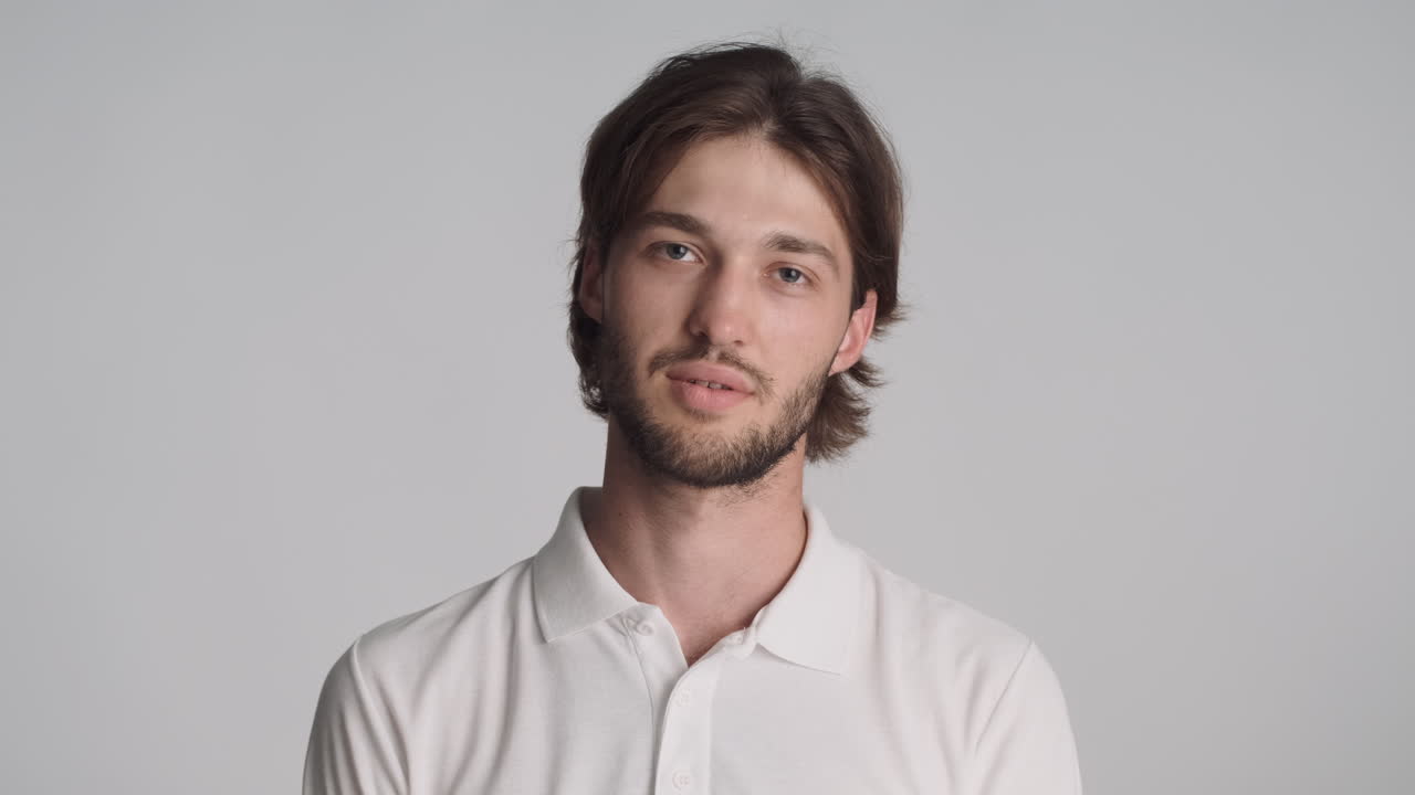 회색 배경에서 카메라 앞에서 피곤한 백인 남자.