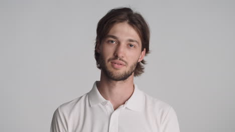 caucasian tired man in front of camera on gray background.