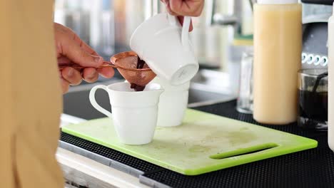 pouring milk and coffee into a cup