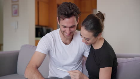 Pregnancy-test,-smile-and-couple-on-sofa-happy