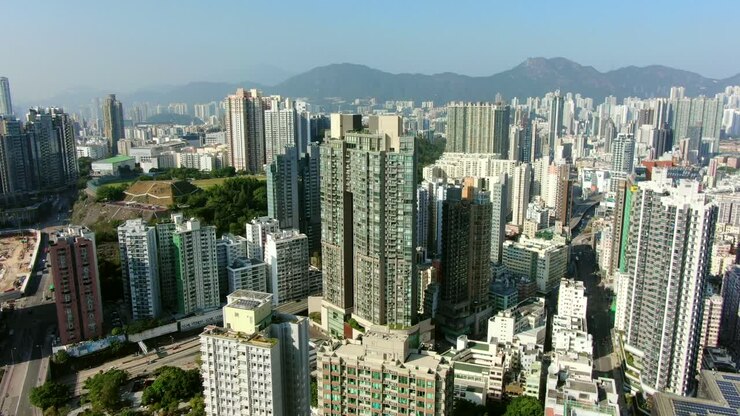 Imagem aérea do centro de Hong Kong com megarrarranha-céus residenciais e tráfego, em um belo dia