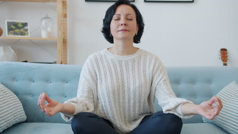 woman meditating on a couch