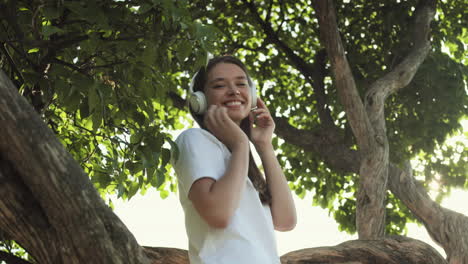woman listening to music among trees