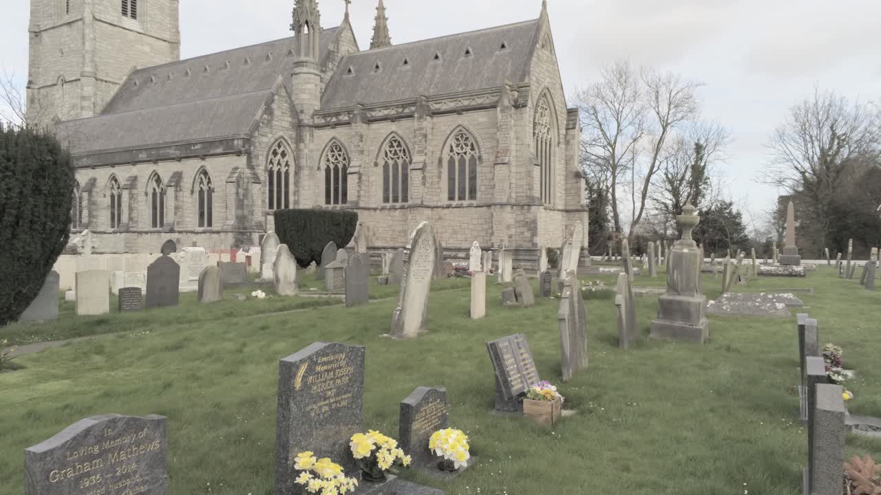 Rural Welsh cemetery garden graveyard headstones in front of ornate white church slow dolly right