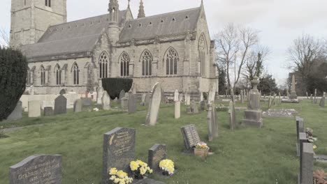 rural welsh cemetery garden graveyard headstones in front of ornate white church slow dolly right