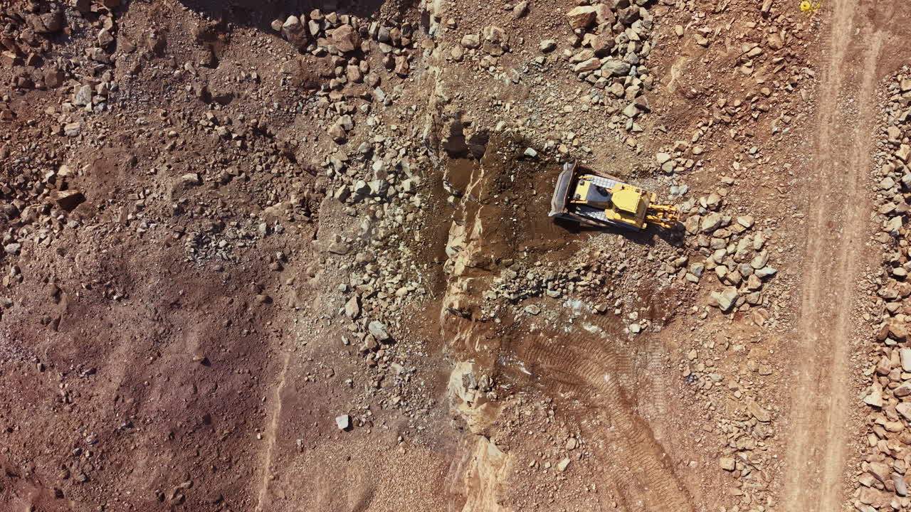 Bulldozer works on rocky terrain during construction project in a rural area