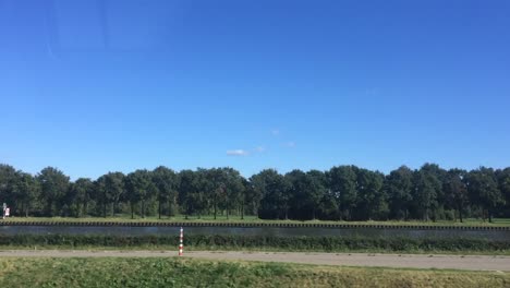 Following-part-of-the-Amsterdam-canal-in-The-Netherlands-with-ships-passing-on-the-waterway-staying-on-the-same-level-as-the-water