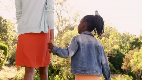 Rear-view-of-mother-and-daughter-are-holding-by-hand