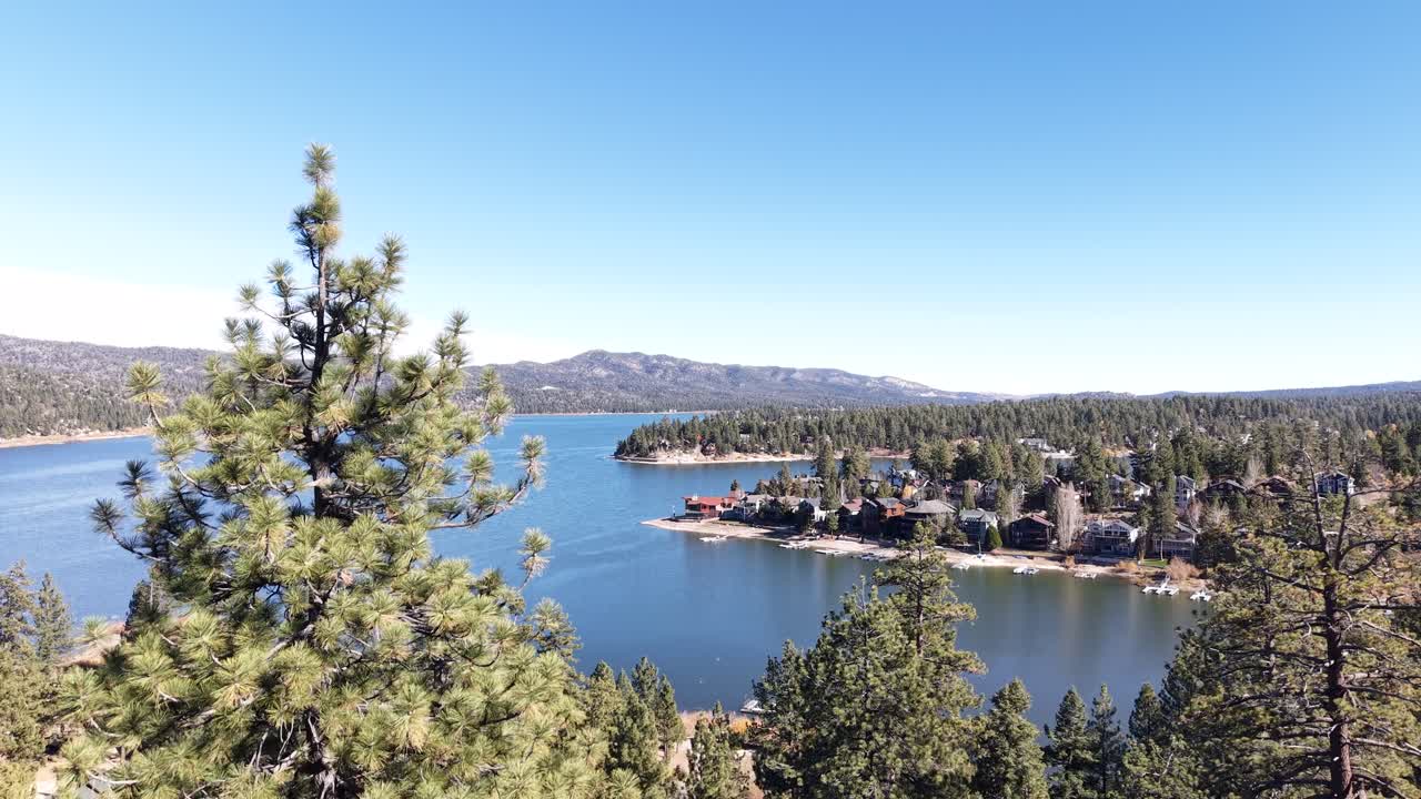 Big Bear Lake from above. Camera moving through the trees to expose a beautiful cinematic view of Big Bear Lake