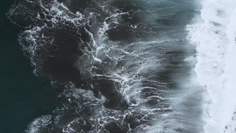 aerial view of some powerful ocean waves crashing into the shore